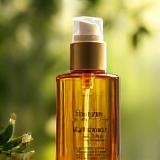 Frasco de óleo capilar Essência Carioca iluminado pela luz natural.